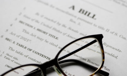 A bill in Congress with glasses resting on top